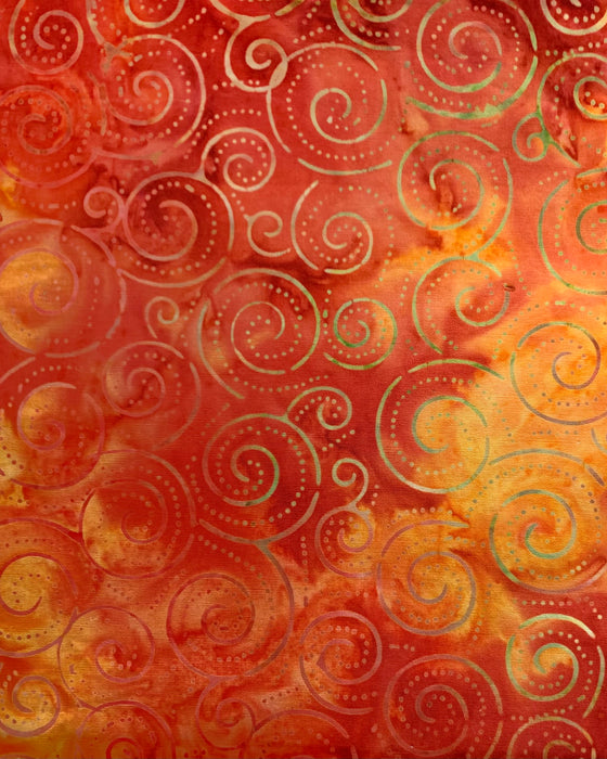 A detail of a cotton cloth cover with dotted and alternating ochre spiral pattern on a red and orange wash background.  