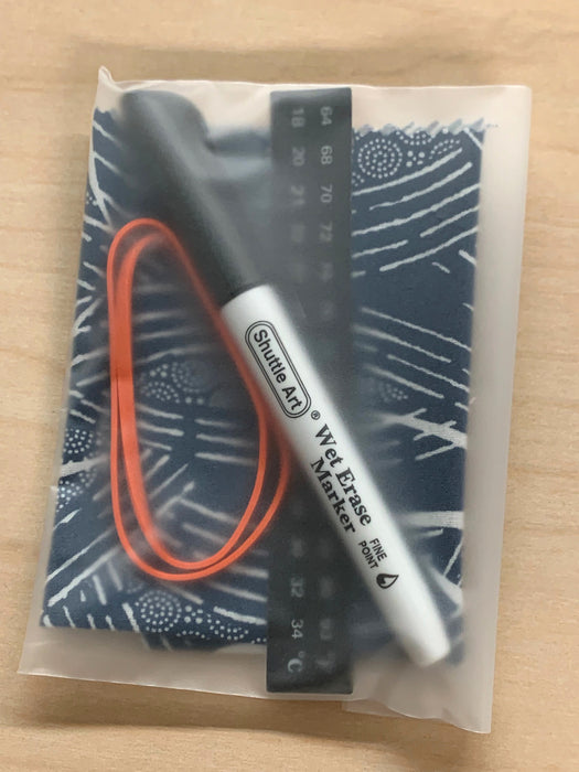A packaged kombucha accessory kit including a wet erase pen, a rubber band, a stick-on thermometer contained in translucent plastic package. 