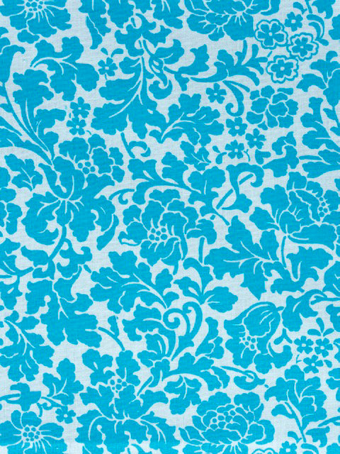 A one gallon glass jar with a colorful floral patterned cotton cover and a rubber band around the top. A stick-on horizontal thermometer is also visible on the jar.